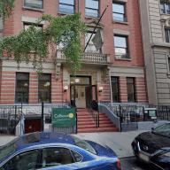 former calhoun school, which is positioned to become a homeless shelter on the upper west side, in the daytime with cars parked in front