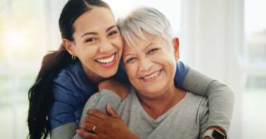 Happy Woman Nurse And Hug Senior Patient In Elderly Care