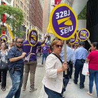 32BJ union members holding signs and in the daytime rally in Midtown to protest wage cuts