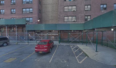 Bronx building in daytime with red car in front