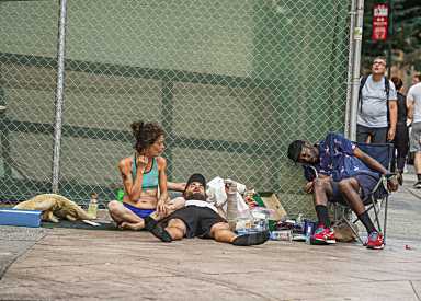 A group of homeless individuals lounge in the sun.