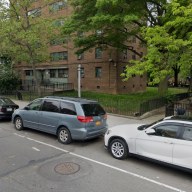 Sumner Houses in Brooklyn with cars parked out front