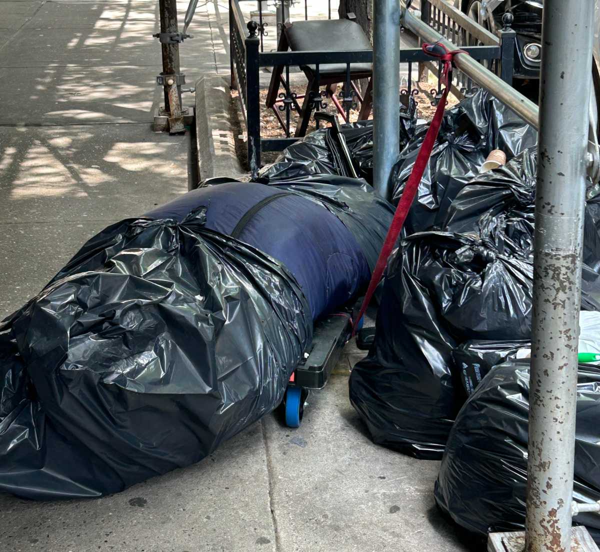 A human body wrapped in trash bags and covered in flies was found Friday on a Kips Bay street, police said.