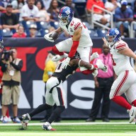 Giants tight end Theo Johnson hurdles a defender in preseason