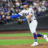 Mets second baseman Jeff McNeil throws to first base.