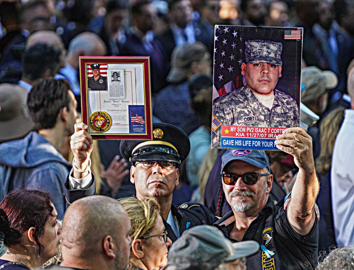 Mourning families lifted photographs of their loved ones skyward as a bell tolled, resounding over solemn observers at the 9/11 Memorial and Museum on Sept. 11, 2024.