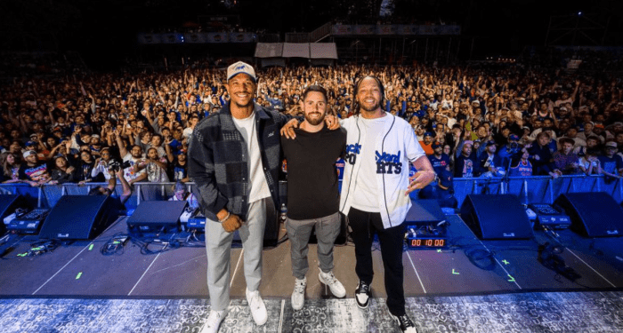 Jalen Brunson Josh Hart Roomates Block Party: Three men stand in front of large crowd in Central park