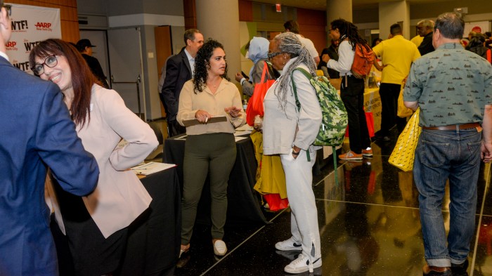AARP and Schneps Media host financial empowerment event for New Yorkers 4 group of people inside a college attending a financial forum