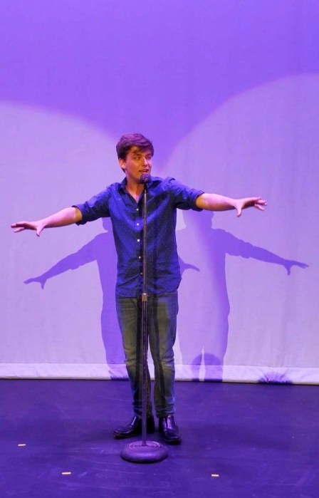 Memorial to Matthew: New holiday show 'The Christmas Express' pays tribute to musician whose life was cut short in 2022 4 man in blue shirt at a microphone on stage