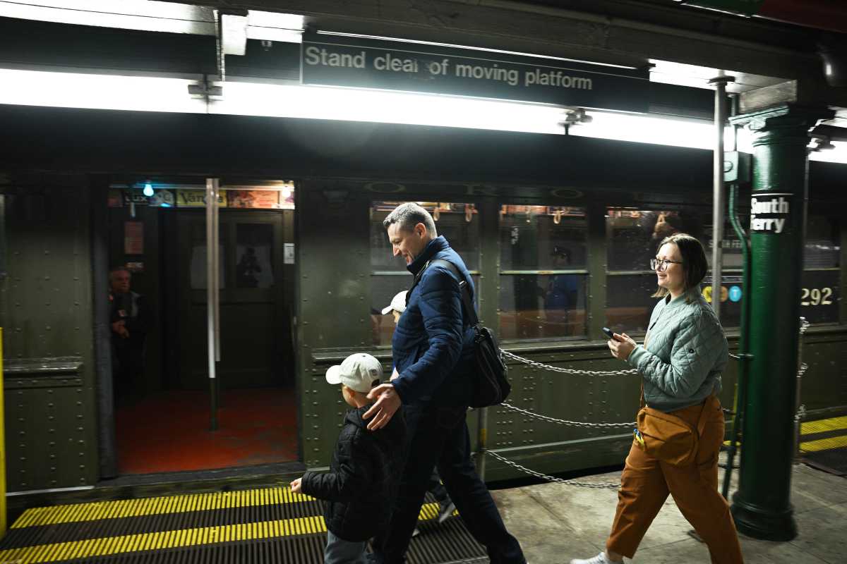 A family gets on the 1917 Lo-V train at the old South Ferry station on Oct. 27, 2024, the 120th birthday of the subway.