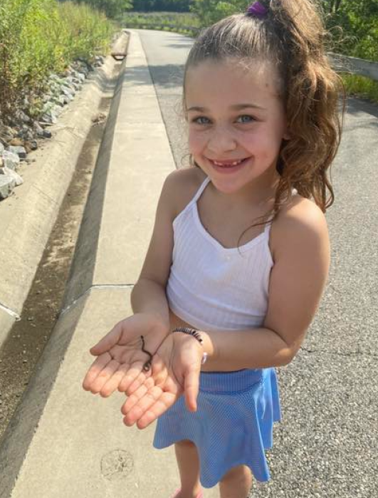little girl holding baby snake at Brookfield Park on Staten Island 