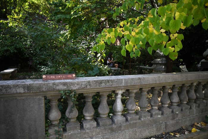 A woman takes a moment to sit at the Elizabeth Street Garden