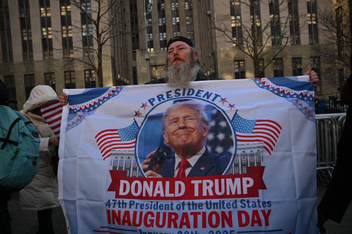 A man holding Donald Trump's banner.
