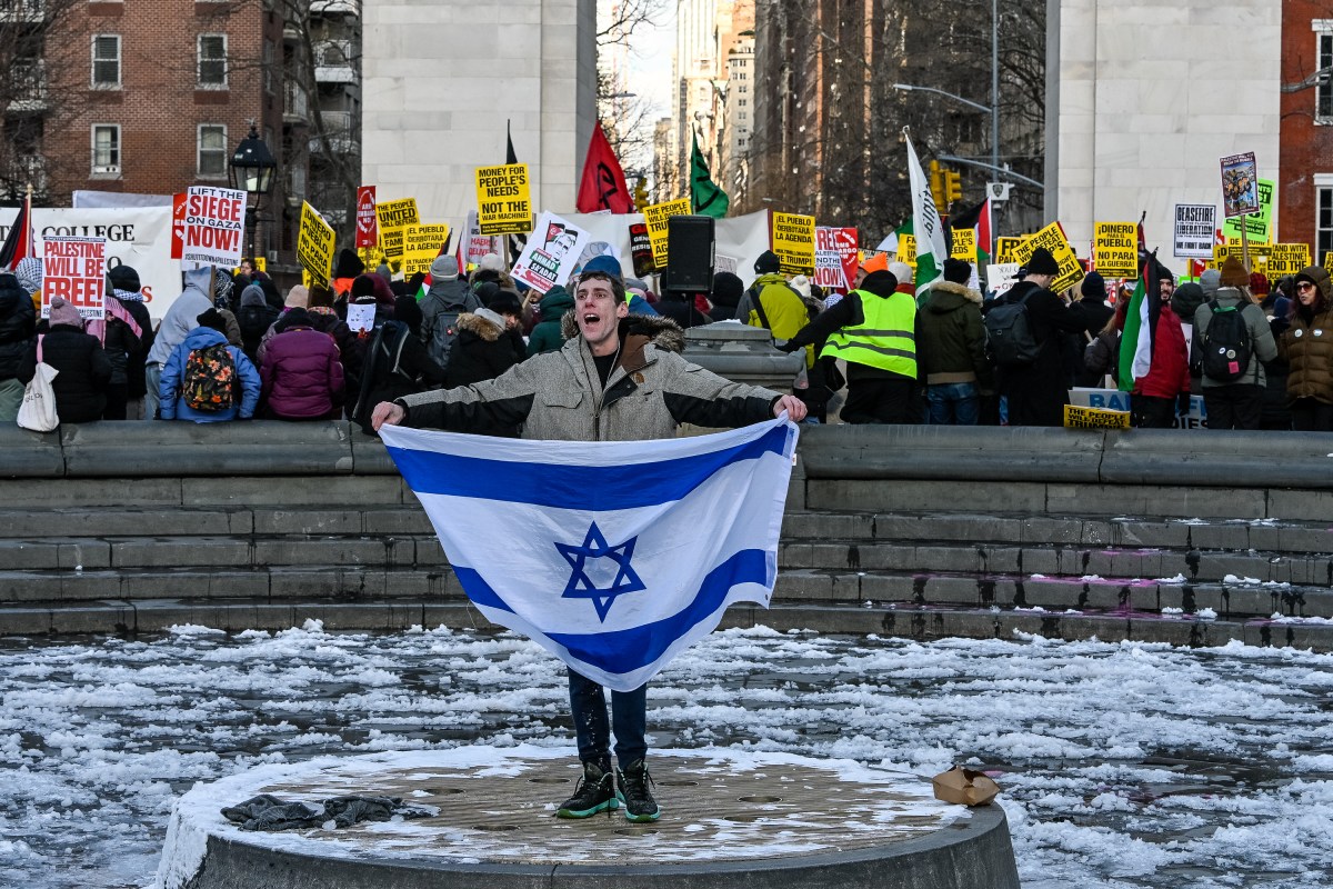 A pro-Israel demonstrator holds up the Israeli flag while the protestors with the People's Forum renewed calls to "free Palestine."