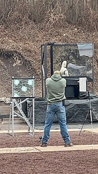 man shooting at bulletproof glass