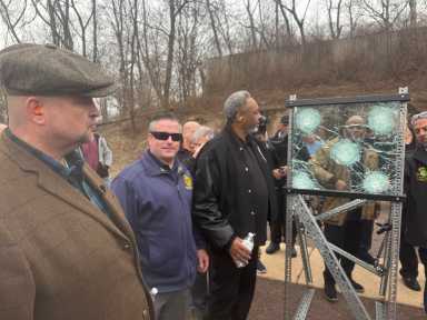 group of people outside at a demo of bulletproof glass