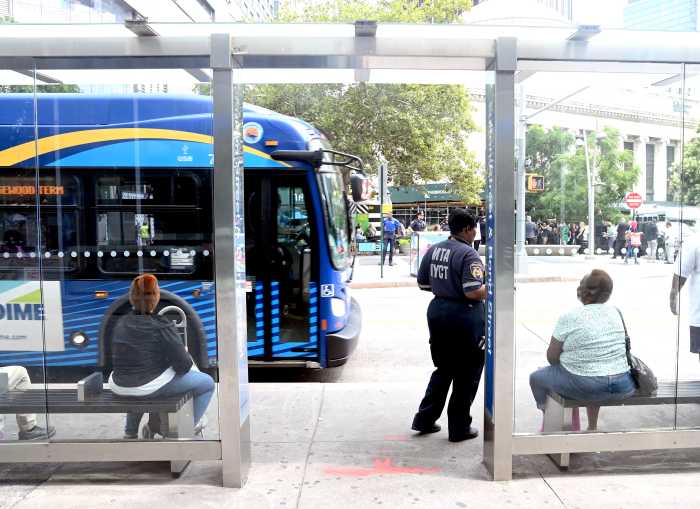 People sitting at a bus stop shelter