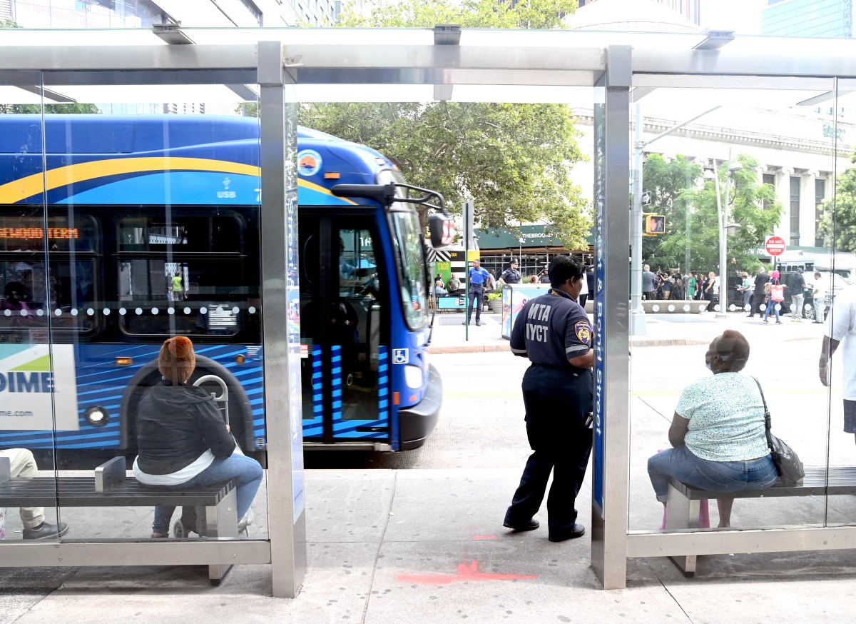 People sitting at a bus stop shelter