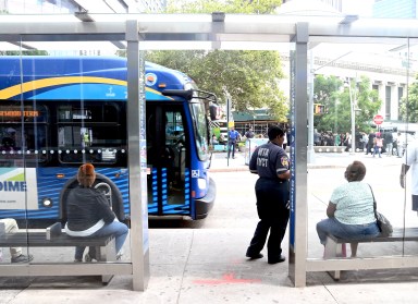 People sitting at a bus stop shelter