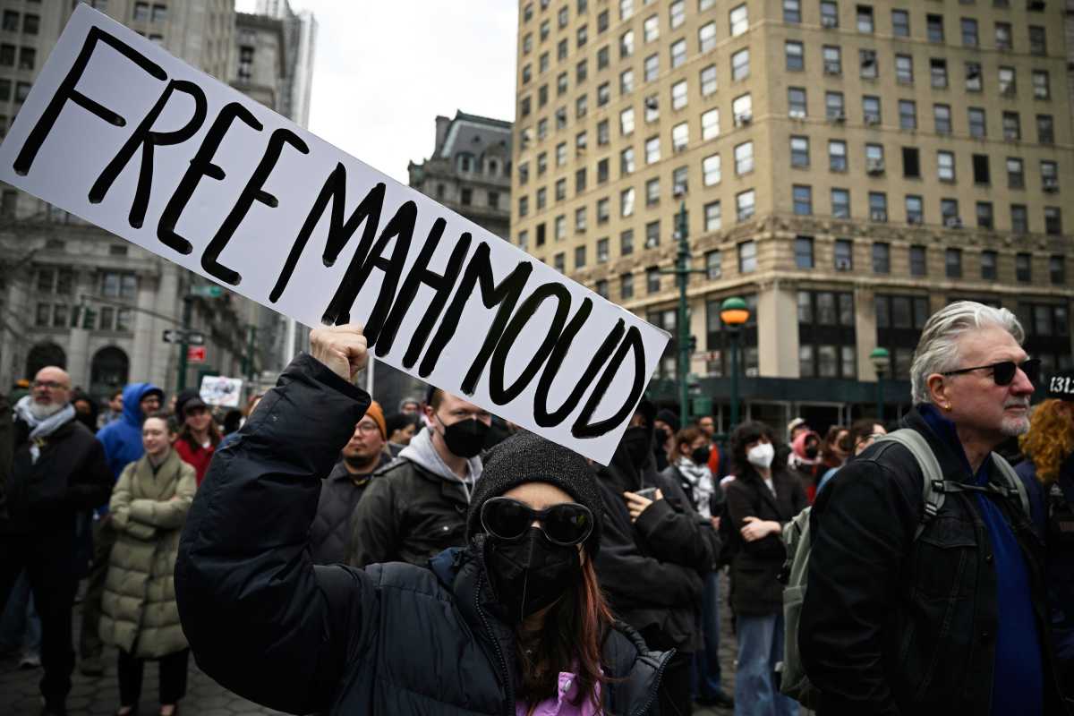 A protestor holds signs in support of Mahmoud Khalil.