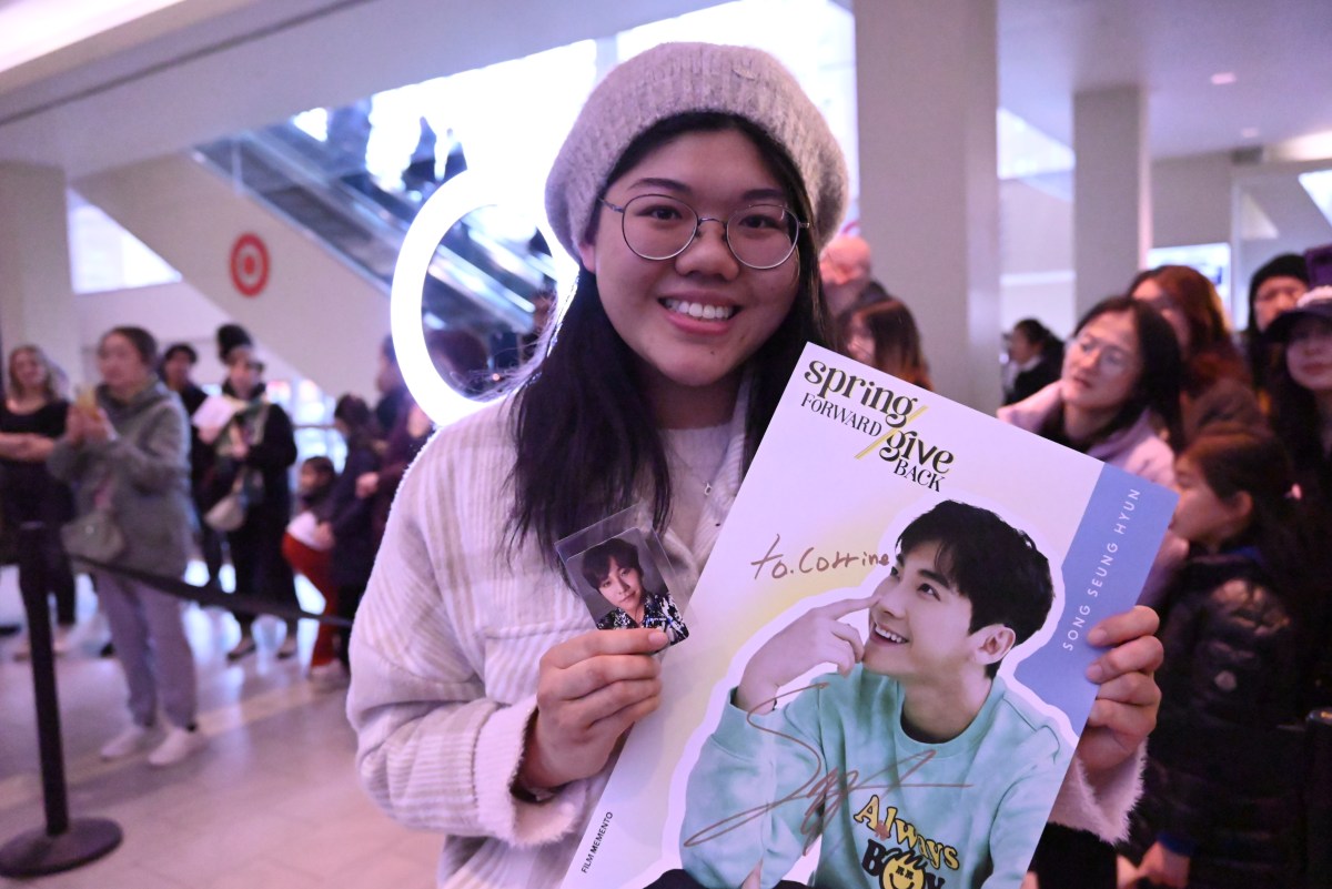 A fan holds a poster signed by Song Seung Hyun.
