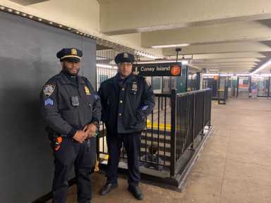 two police officers in a subway station