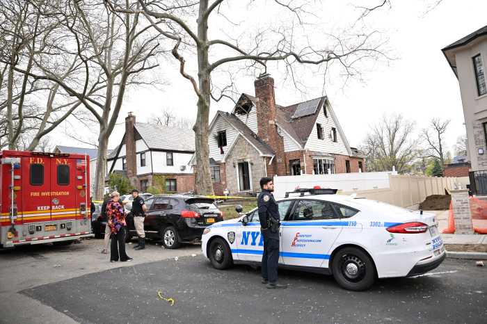 police car in front of a house that was demolished by fire