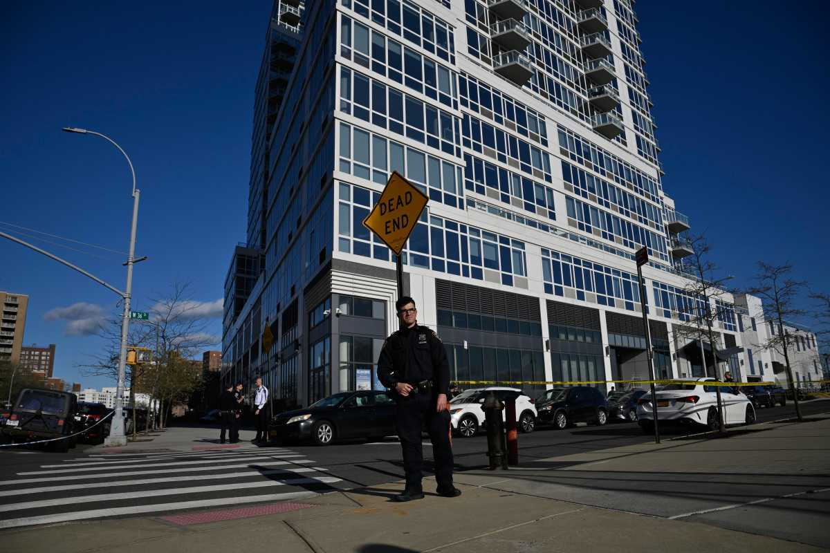 Cop ropes off scene of deadly Brooklyn shooting in front of apartment building.