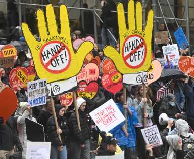 Protesters hold Hands Off signs in march against Trump in Manhattan
