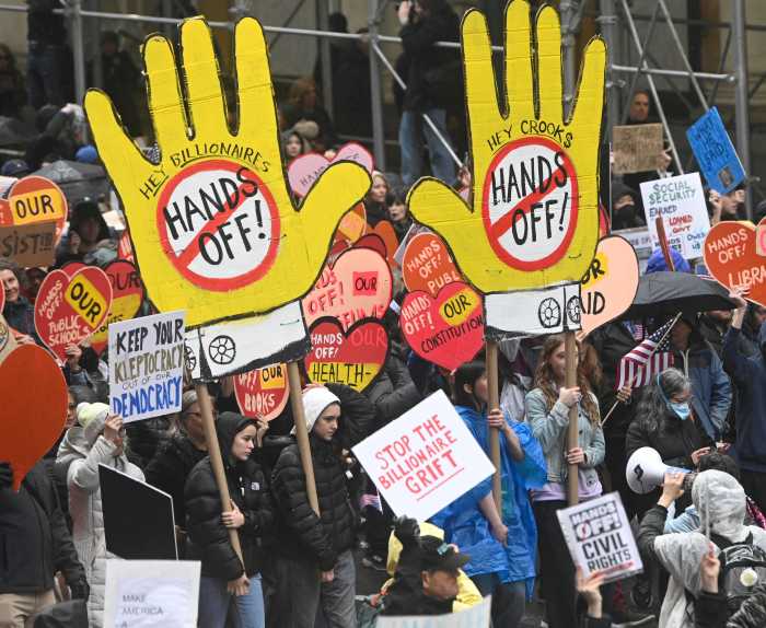 Protesters hold Hands Off signs in march against Trump in Manhattan