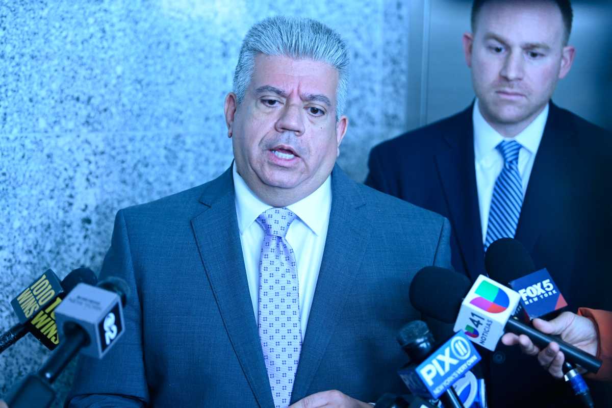 man wearing a suit talking with reporters in Brooklyn