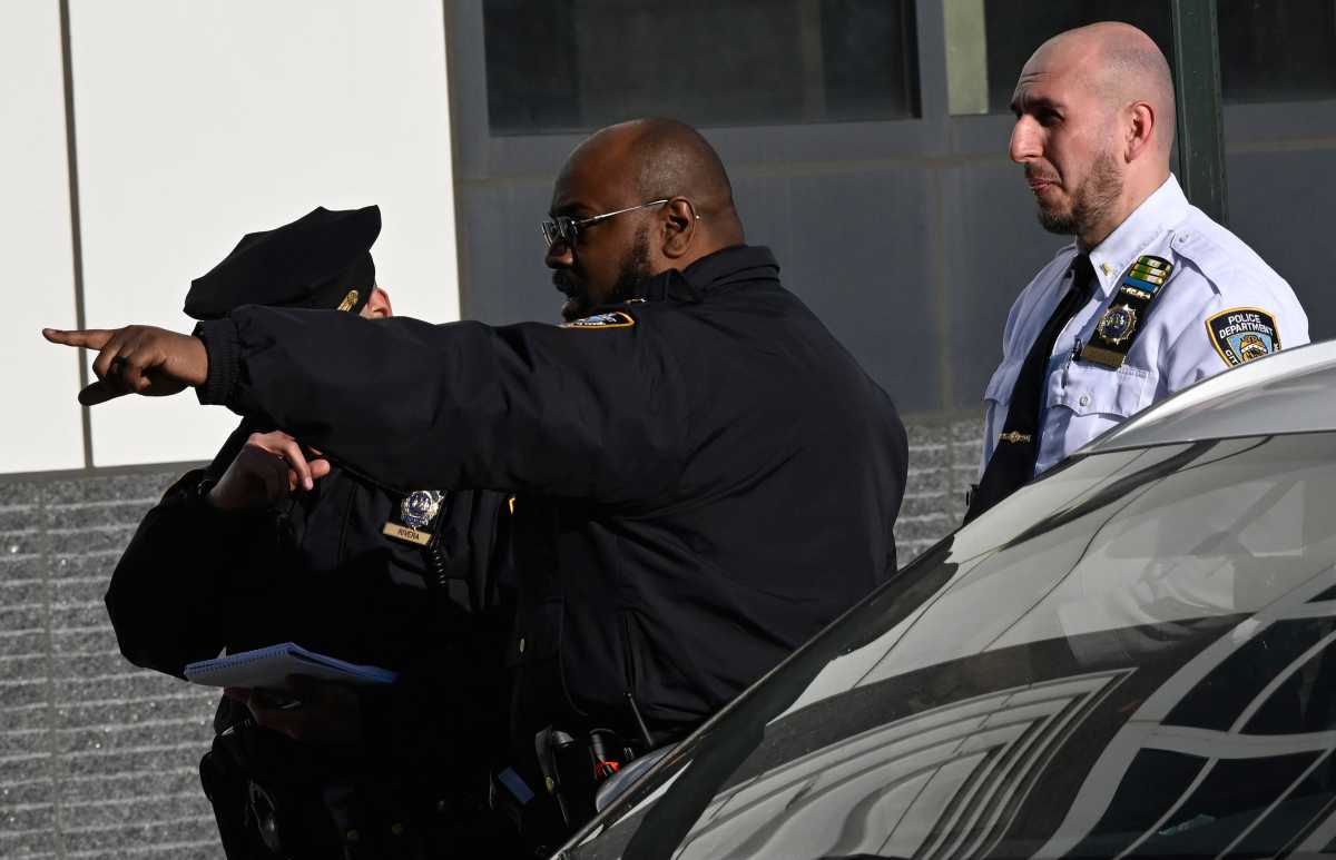 Police officer pointing at scene of Brooklyn shooting