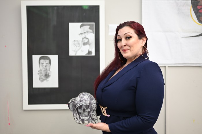 Manager of the Herbert Von King Cultural Arts Center Colleen Flood poses alongside the hat designed by her husband, which sparked the idea for Bed-Stuy exhibition