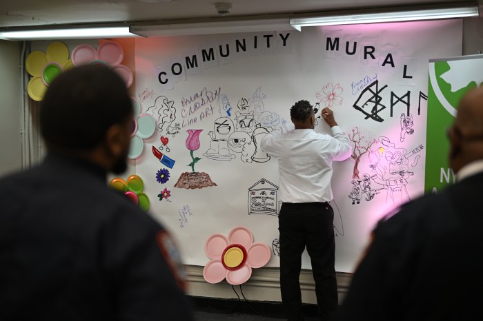 Brian Croskey tags the mural that attendees are asked to contribute within the theme of 'community.' Parks staff plan to digitize the mural once the exhibit closes