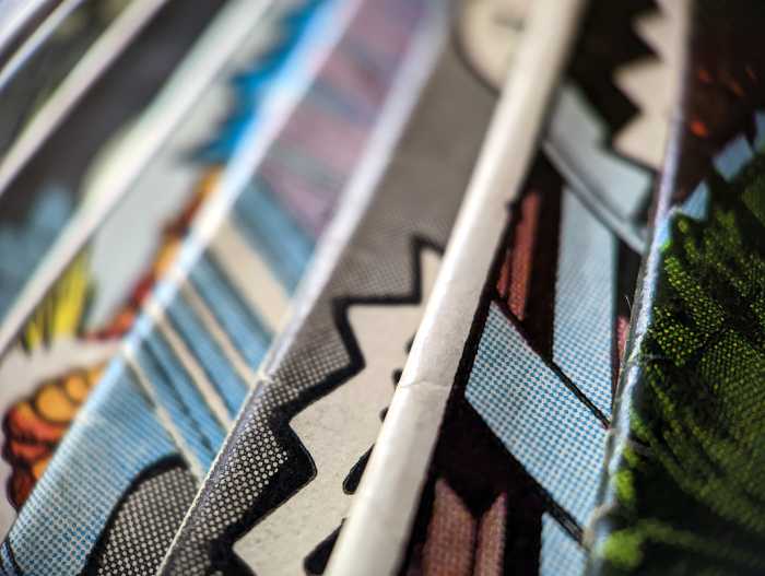 Closeup view of an old comic book collection creates a colorful background paper texture with abstract shapes