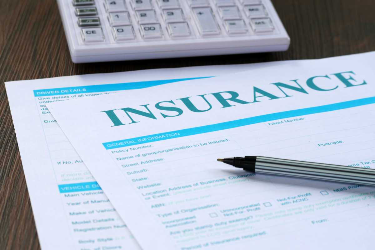insurance form, calculator and pen on the table