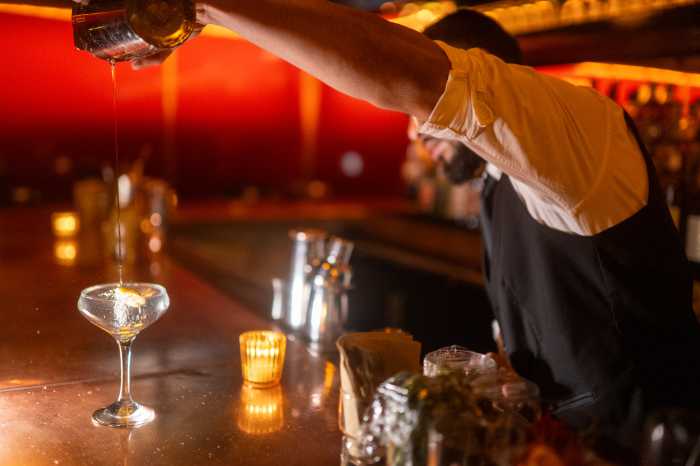 a bartender at Bar Merce pouring a drink
