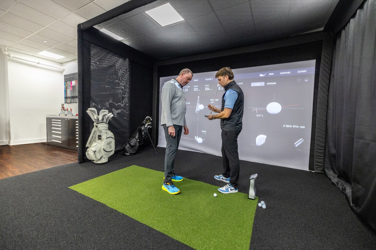 True Spec Golf brings custom fitting experience to Chelsea Piers 4 a True Spec Golf employee works with a customer in store,