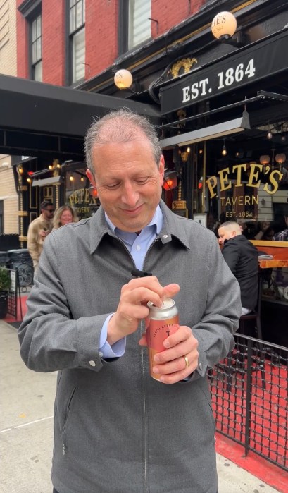 man with a drink outside a restaurant