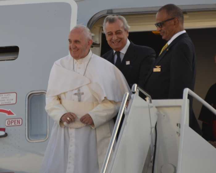 Pope Francis smiling as he departs a plane in New York