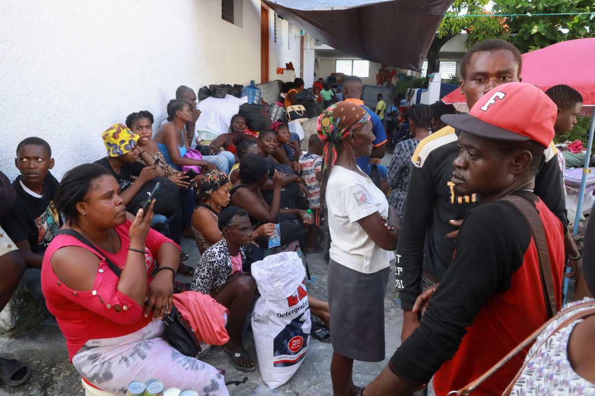 Haitian TPS holders to present arguments in lawsuit against Trump administration 2 Haitian refugees stand on line at a camp