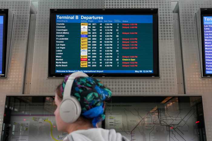 Passenger with screen of delayed flights at Newark Airport