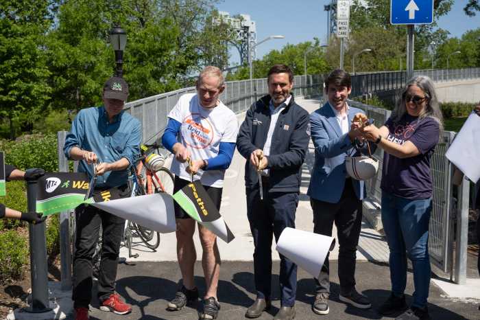people cutting a ribbon on a bike path