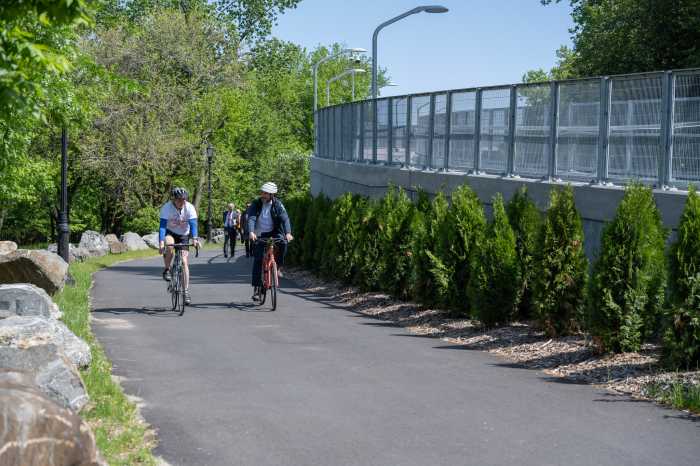 group of people riding bikes on a path