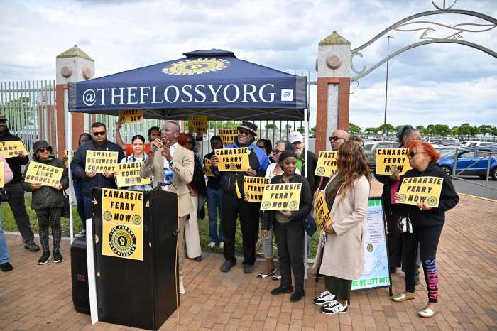 a group of people in Brooklyn behind a podium holding signs that read Canarsie ferry now