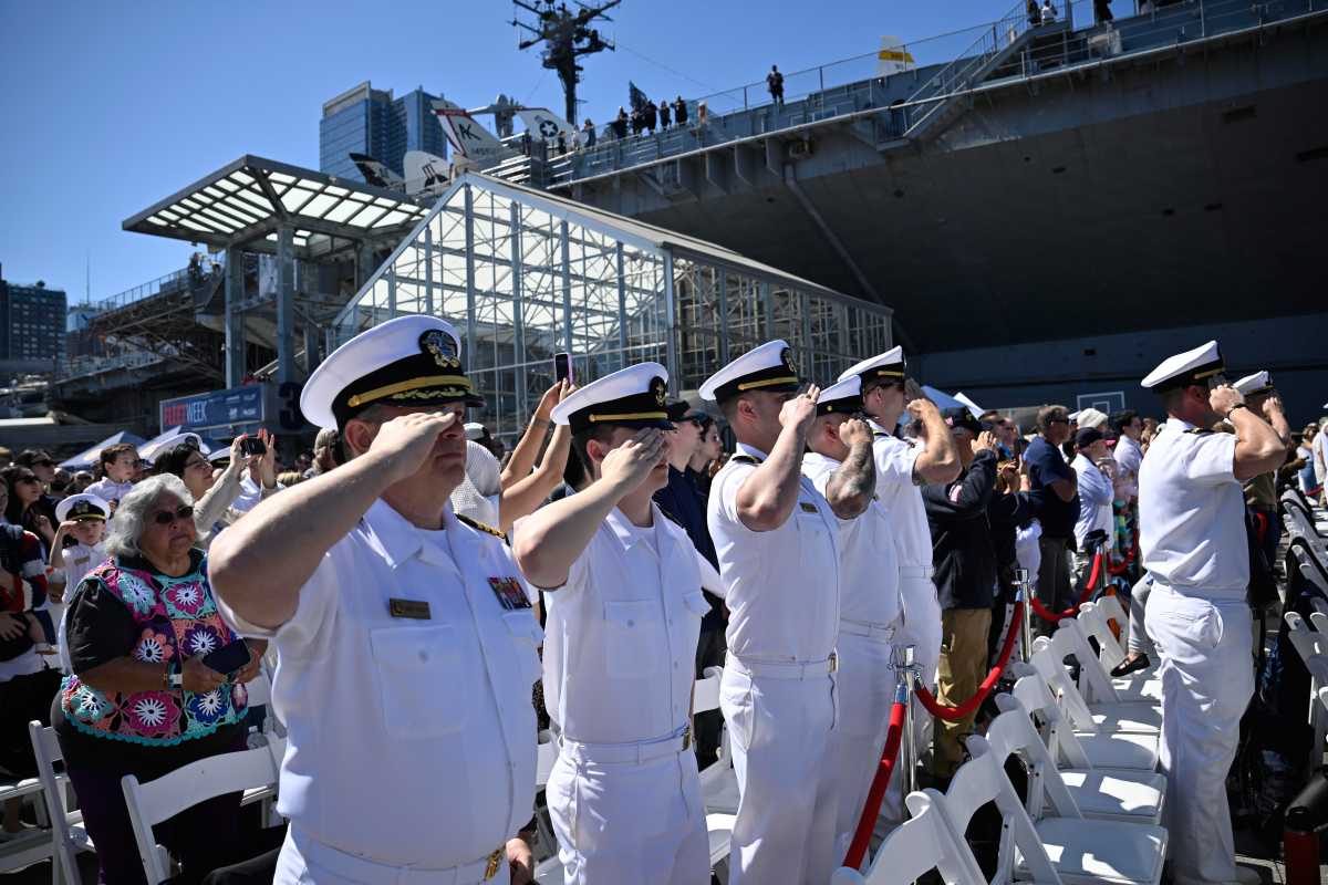 Navy members salute on Memorial Day at the Intrepid Sea Air and Space Museum