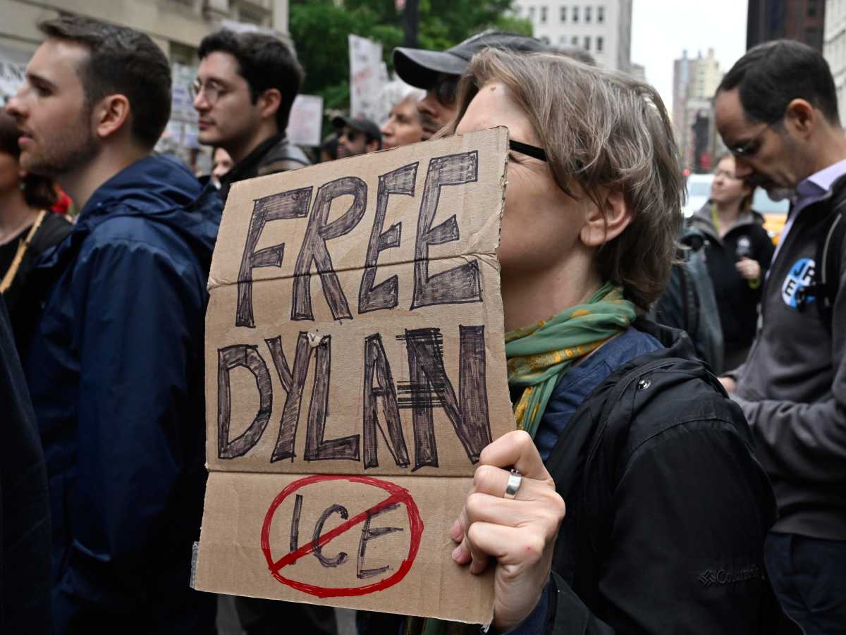 a rallier holds a sign that says "Free Dylan" over a symbol crossing out the word "ICE"