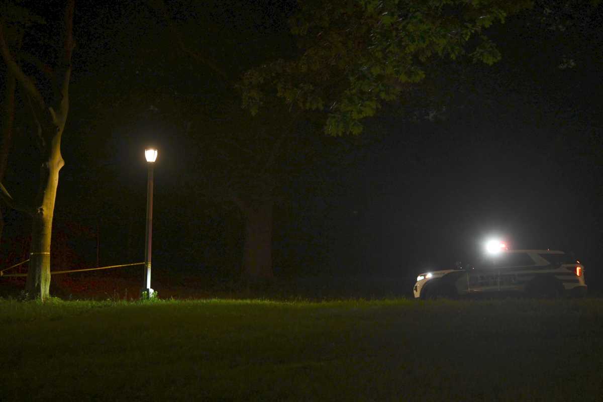 Police car in dark Brooklyn park after shooting
