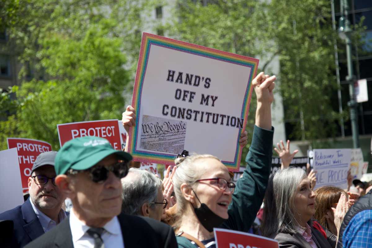 Lawyer holding up sign Hands off my Constitution at Law Day rally in Foley Square