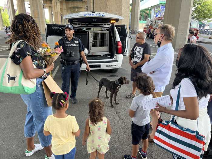 police officer and dog standing next to a group of people